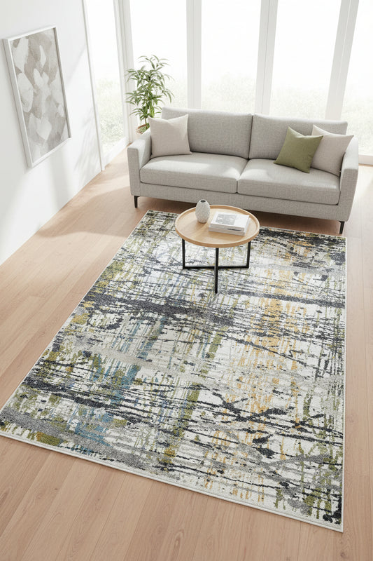 An abstract area rug featuring a distressed, painterly design with vertical and horizontal brushstrokes in gray, white, blue, olive green, and ochre yellow.