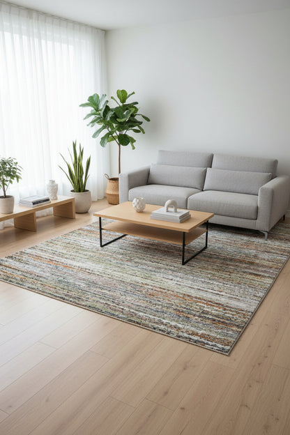 A rectangular area rug with a distressed, textured horizontal stripe pattern in shades of gray, beige, white, and rust orange.