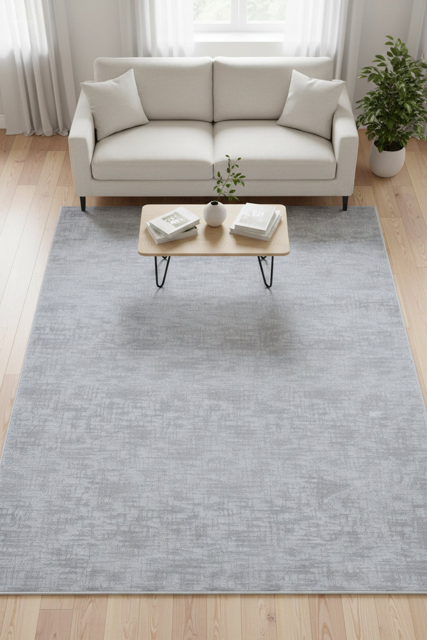 A square area rug with a textured, heathered light gray and silver pattern, shown flat against a white background.