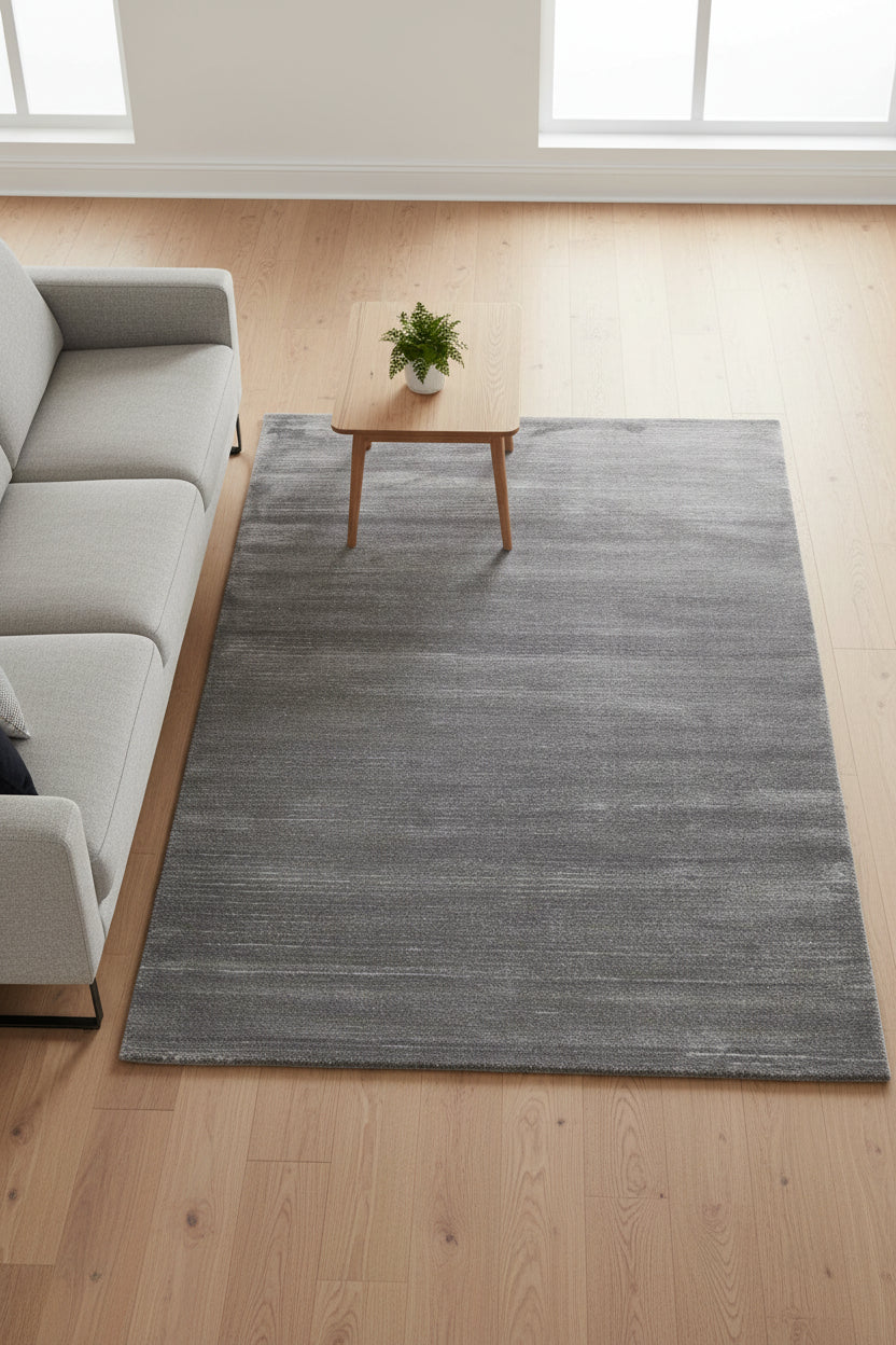 A rectangular area rug with a textured, heathered charcoal gray surface, shown flat against a white background.