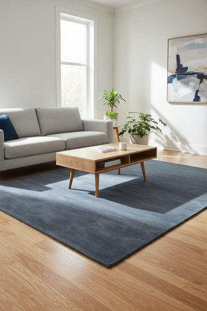 A rectangular area rug in a dark slate blue-gray color, shown from a top-down view against a white background.