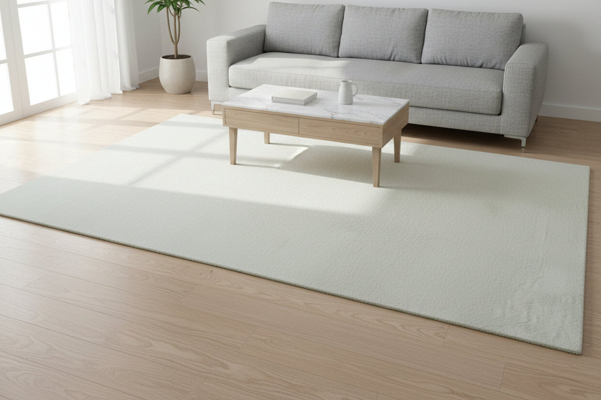 A rectangular area rug in a light cream or off-white color, shown from a top-down perspective against a white background.