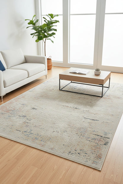 An abstract distressed area rug with a vintage pattern in beige, cream, muted blue, and terracotta orange, shown flat against a white background.