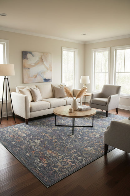 A rectangular vintage-style area rug with an intricate floral and medallion pattern in faded blue-gray, beige, and muted rust tones, shown flat against a light neutral background.