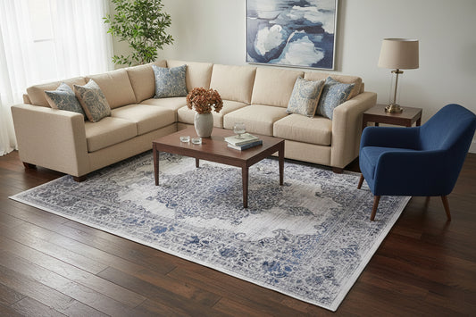 A rectangular area rug with a distressed traditional pattern in shades of blue, gray, and off-white, shown from a top-down perspective on a white background.