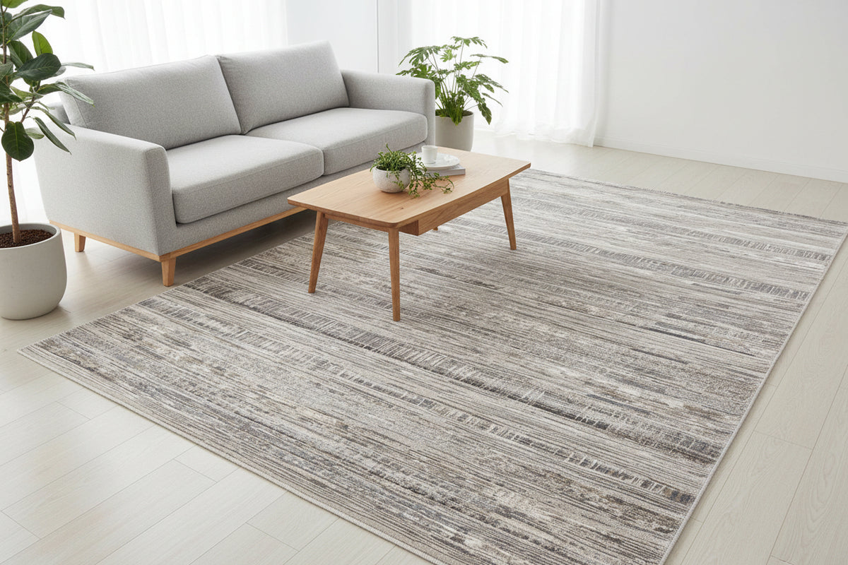 A rectangular area rug with a distressed horizontal stripe pattern in shades of gray, beige, and white, shown from a top-down perspective on a white background.