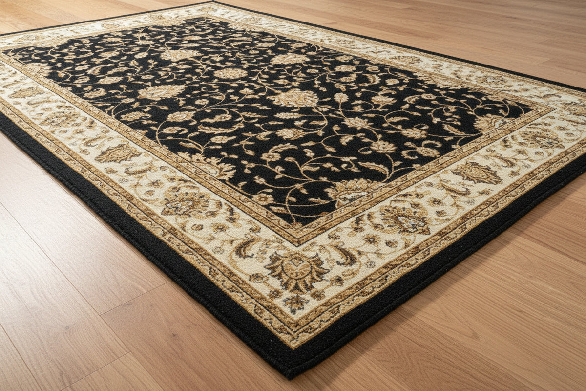 A traditional oriental-style area rug with a black center field decorated with intricate beige and gold floral motifs, surrounded by a wide cream-colored border with detailed floral patterns.