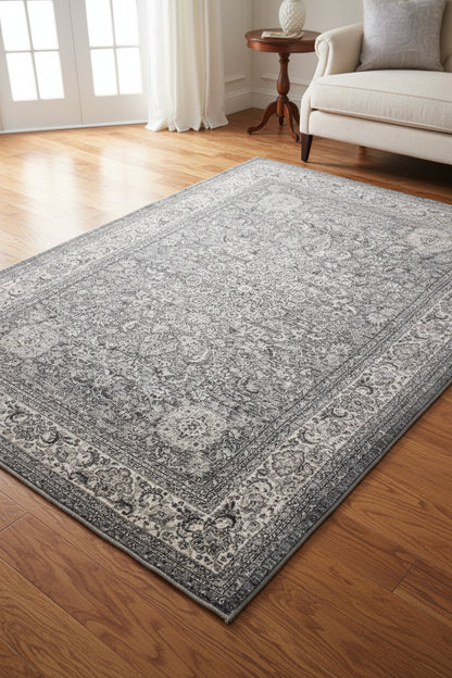 A square area rug with an intricate traditional floral and medallion pattern in shades of gray, beige, and off-white.