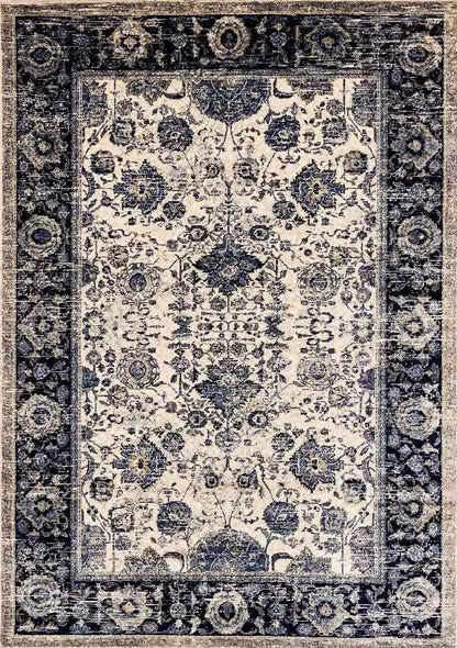 A rectangular area rug with an ornate traditional floral pattern, featuring a cream center field and a dark navy blue border.