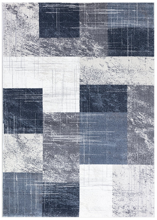 A square area rug with a modern abstract patchwork design in shades of navy, slate blue, charcoal, and off-white, featuring distressed textures and horizontal line patterns.