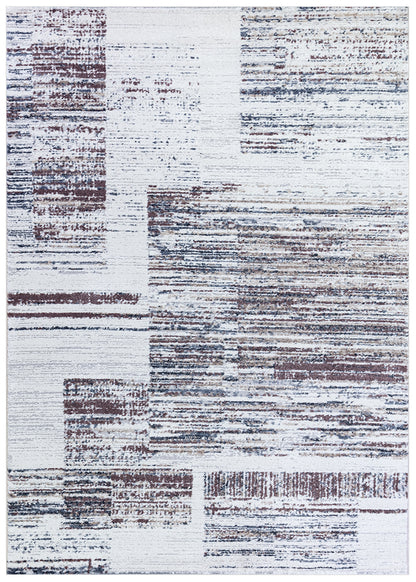 An abstract area rug featuring a distressed geometric pattern with blocks of white, gray, and muted brown.