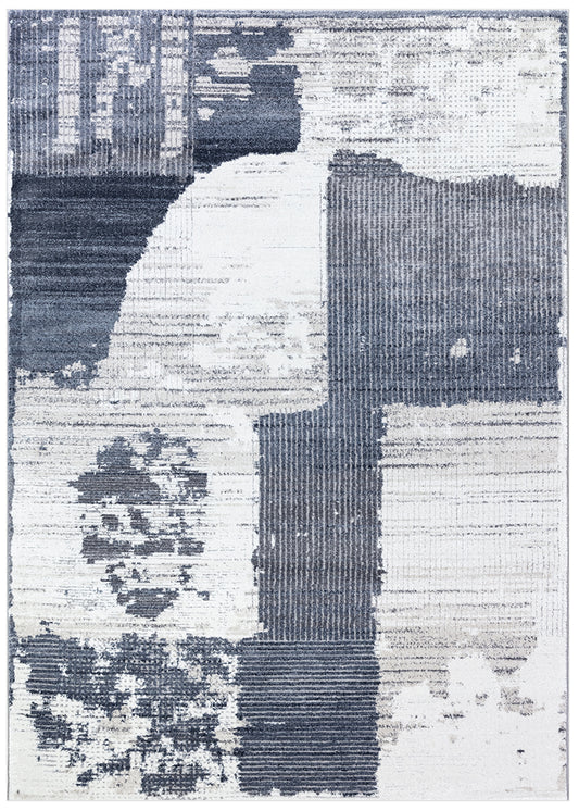 An abstract area rug with a distressed, textured block pattern in slate blue, navy, and off-white.
